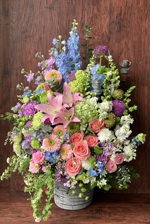 華やかな花材を贅沢に使用した淡い色合いのアレンジメント花